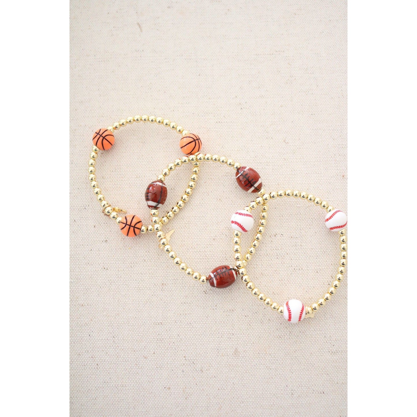 basketball theme bracelet shown with the football and baseball theme stretch bracelets