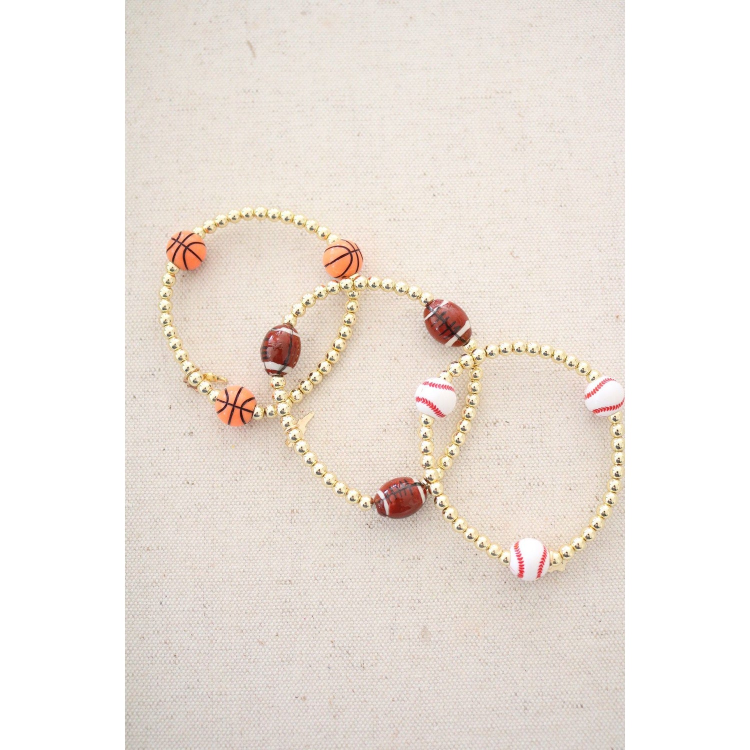 basketball theme bracelet shown with the football and baseball theme stretch bracelets