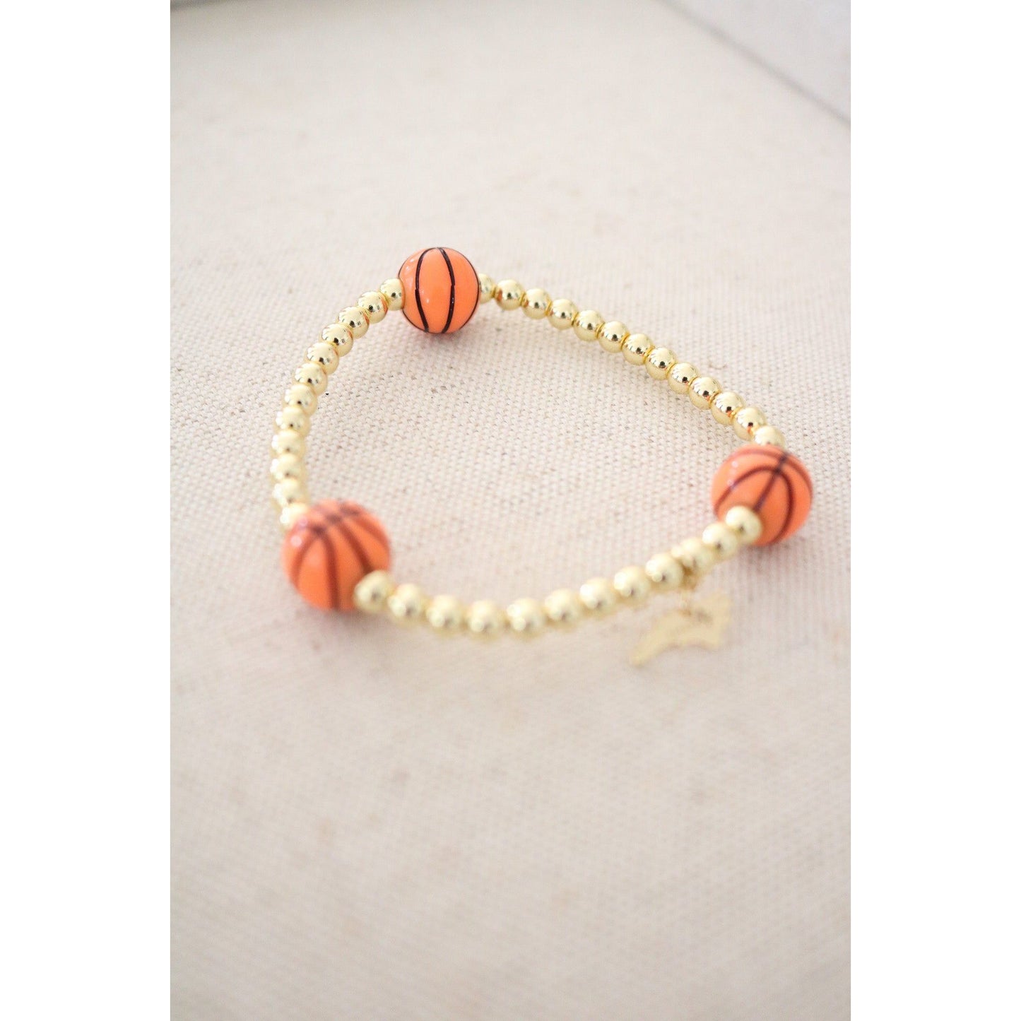 stretch bracelet with three basketball beads and gold hematite ball beads