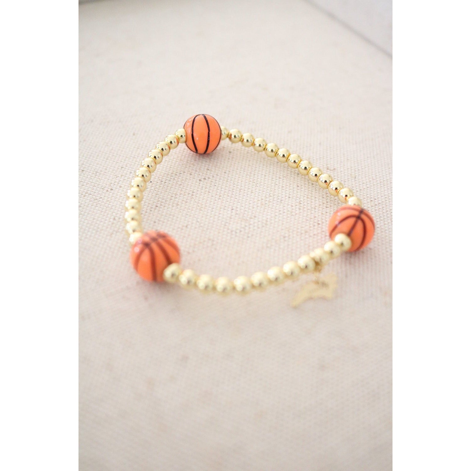 stretch bracelet with three basketball beads and gold hematite ball beads