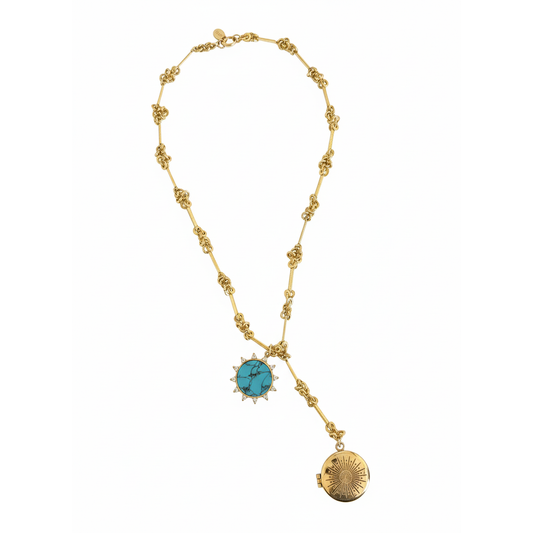 Gold necklace with turquoise pendant and brass engraved starburst locket on a white background