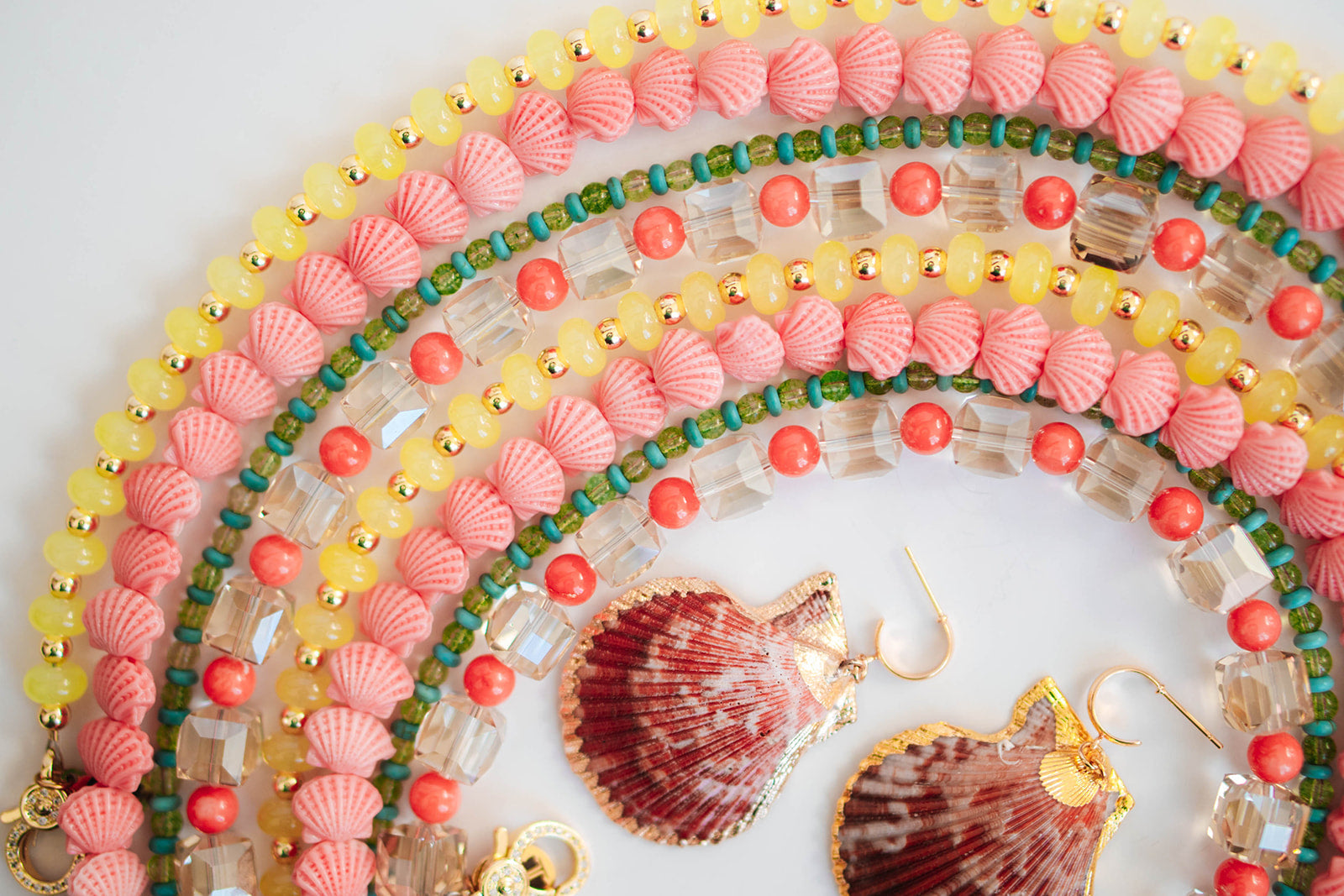 Colorful beaded necklaces with shell accents on a white background