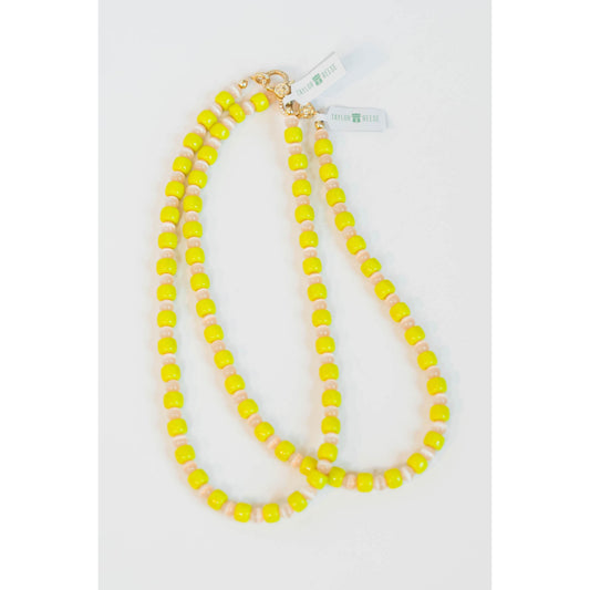 two neon yellow beaded necklaces with glass roller beads in between and a gold pave clasp