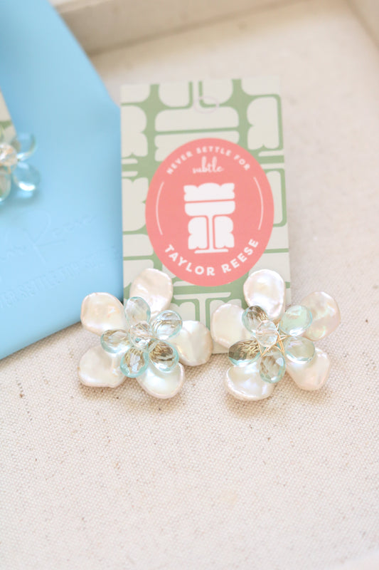 Handcrafted custom bridal earrings made in North Carolina featuring mother of pearl petals and blue quartz stones, designed for a beach wedding.