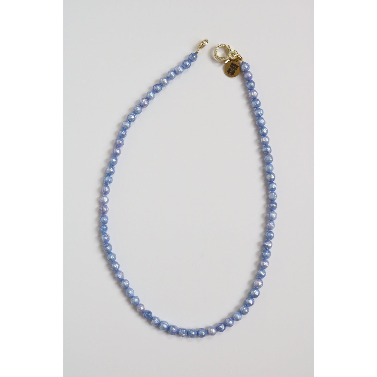 A single strand of light blue freshwater pearls with a pavé clasp and Taylor Reese branded tag.