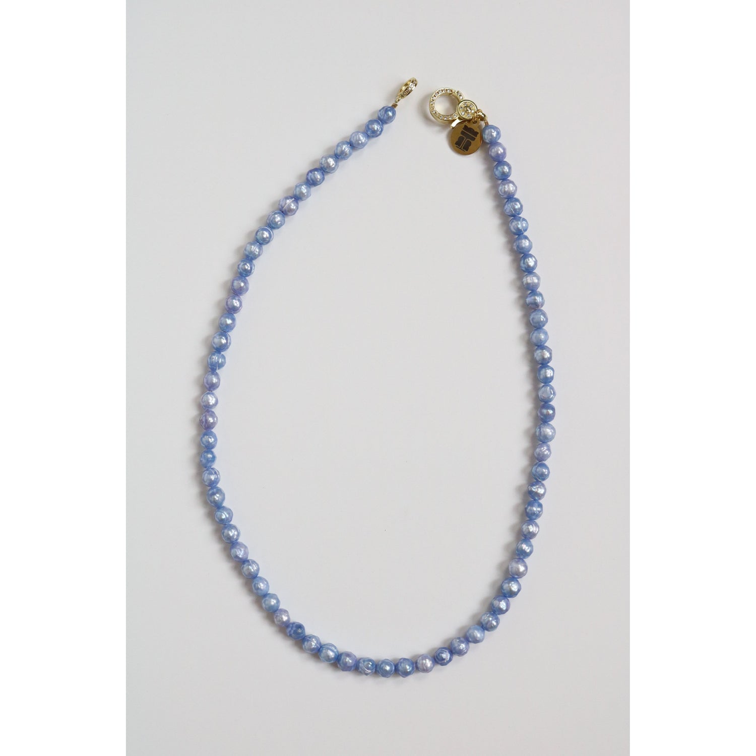 A single strand of light blue freshwater pearls with a pavé clasp and Taylor Reese branded tag.