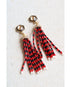 Red and black beaded tassel earrings on a white background