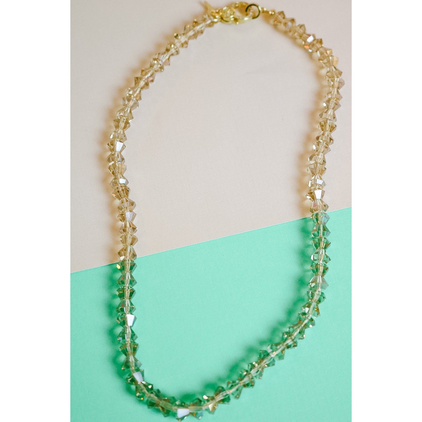The crystal bow hand knotted necklace features a repeating bow pattern on a 100% silk cord