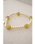 white and yellow evil eye beads on a gold hematite stretch bracelet