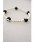 white and black evil eye beads on a gold hematite stretch bracelet
