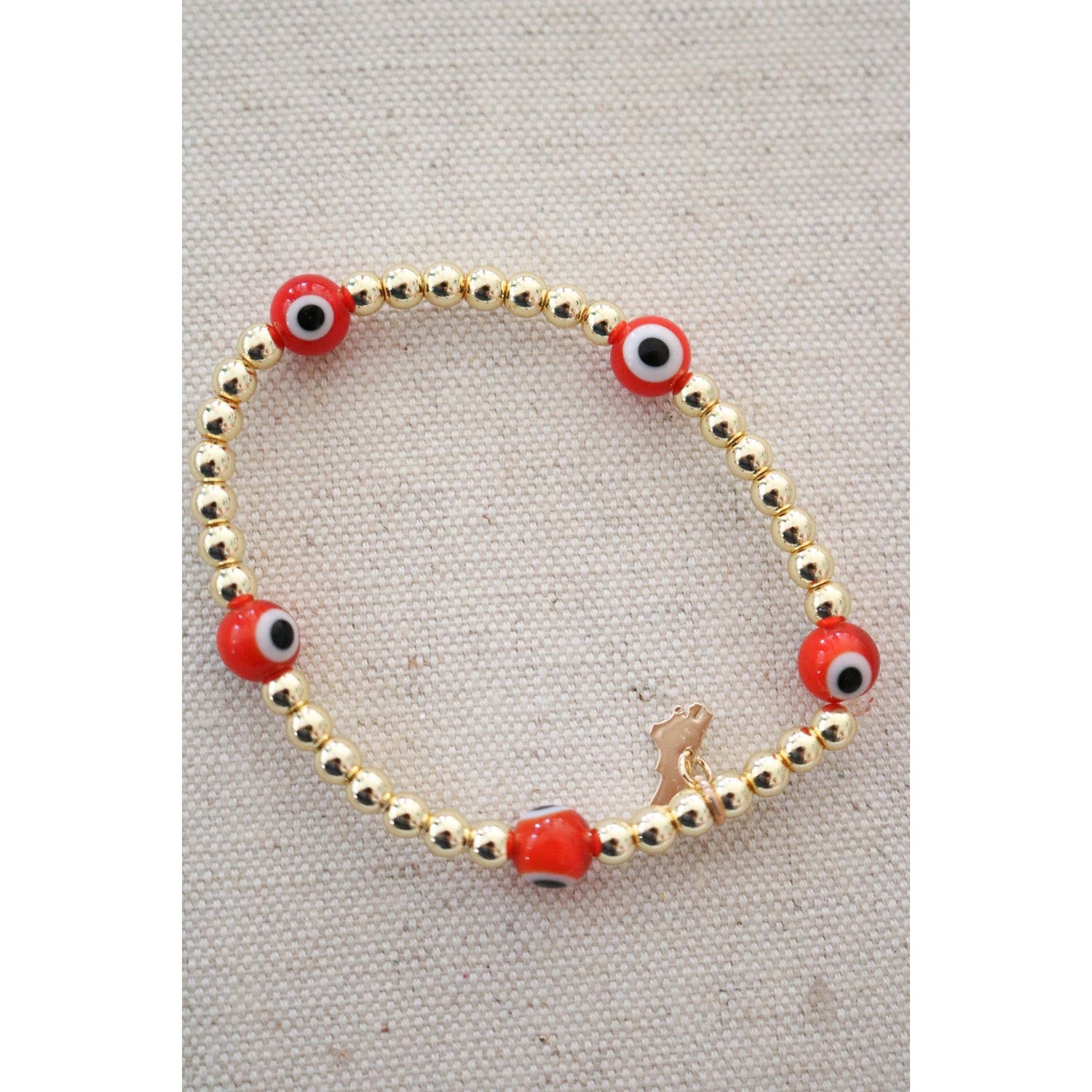orange and white evil eye beads on a gold hematite stretch bracelet