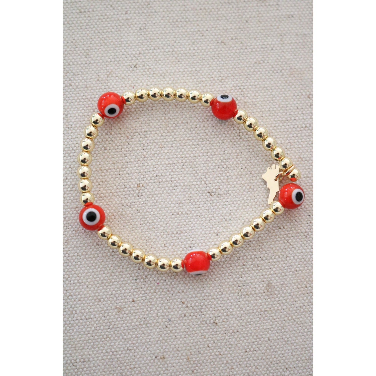 red and black evil eye beads on a gold hematite stretch bracelet
