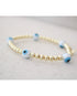 white and blue evil eye beads on a gold hematite stretch bracelet