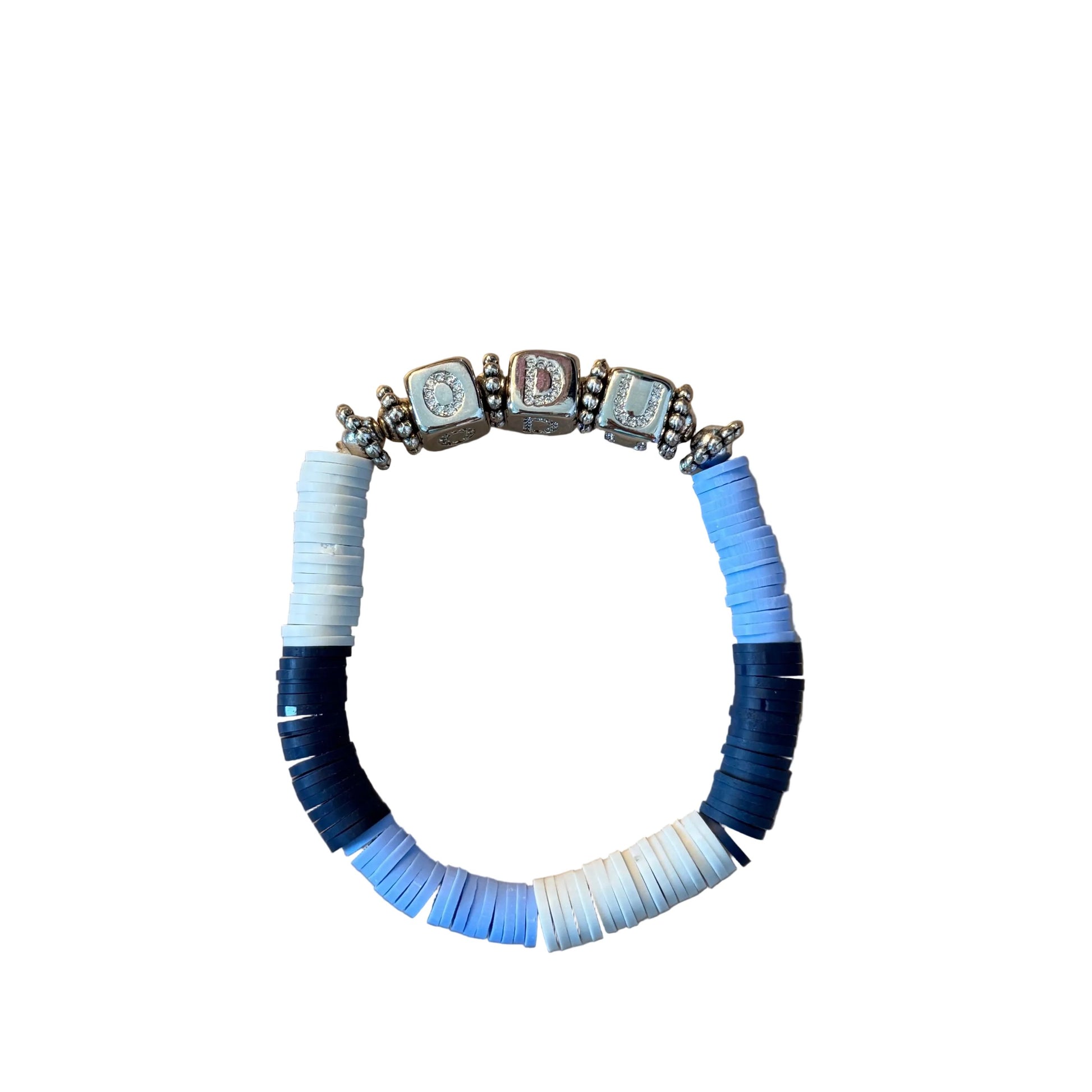 A beaded stretch bracelet with alternating light blue, navy blue, and white disc beads, accented by four silver-toned charm beads at the top, displayed on a wooden surface.