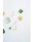 collection of various crystal pendants with gold frames in green, aquamarine, glass, and turquoise against a light background