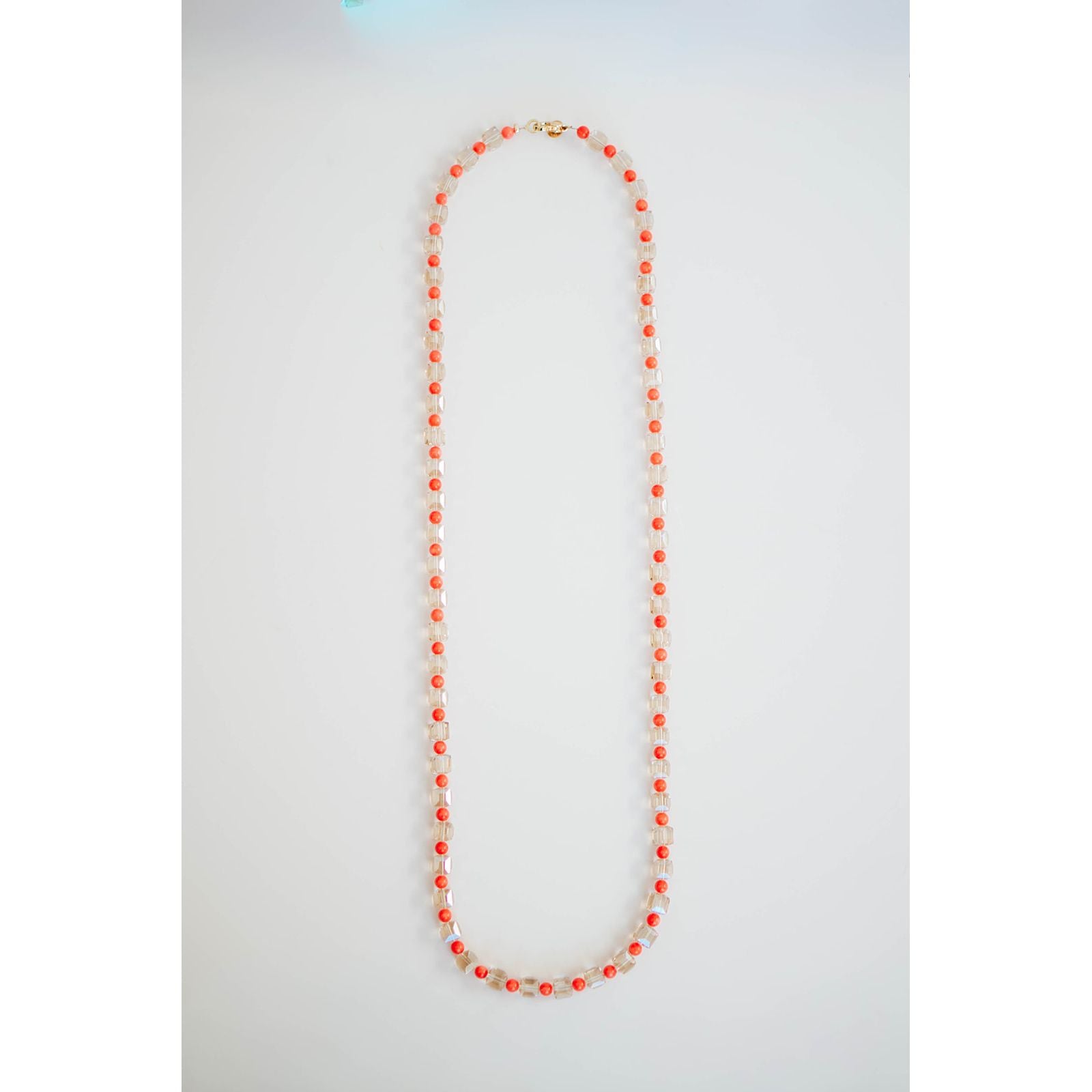 single strand crystal and coral long beaded necklace with gold-tone pavé clasp.