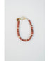 A bracelet with a pattern of goldstone and pavé beads are strung on cord with a pavé clasp and logo charm.