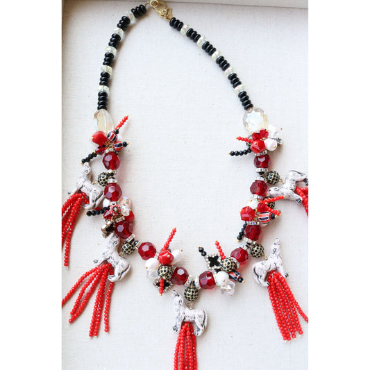 Red crystal beaded tassels are topped with ceramic wolf beads on a red and black beaded necklace with pave clasp. 