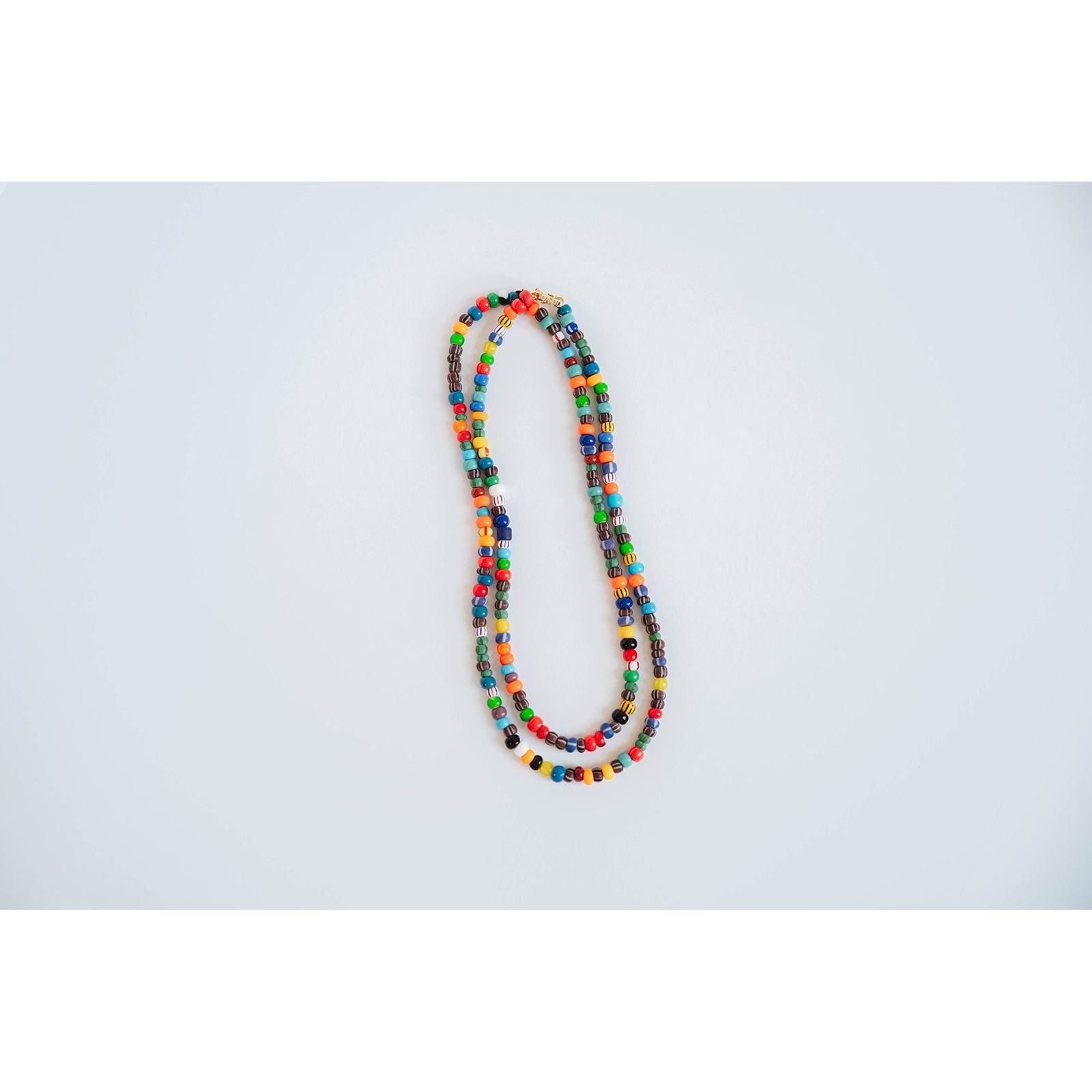 layered necklaces with multicolored glass beads on a light background