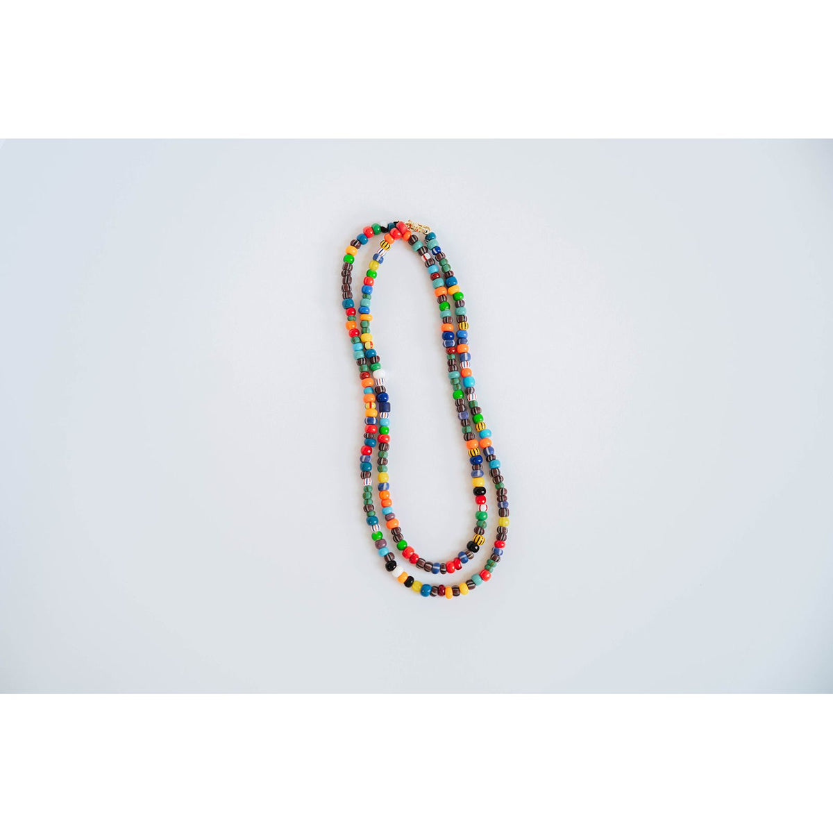 layered necklaces with multicolored glass beads on a light background
