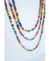 close-up shot of 3 layered multicolor beaded necklaces on a light background