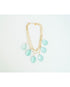 Gold layered chain necklace with teal teardrop pendants on a light grey background