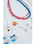 Close-up of various baseball-themed red white and blue necklaces and with baseball beads and baseball game charms on a white background