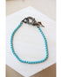 light blue box chain bracelet with a pave gunmetal lever clasp on a white background