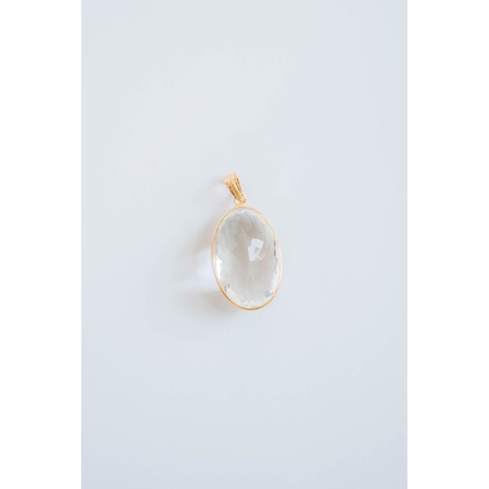 textured crystal pendant with a gold frame on a light gray background
