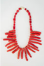 red coral collared necklace with coral-like charms draping the neck against a light background