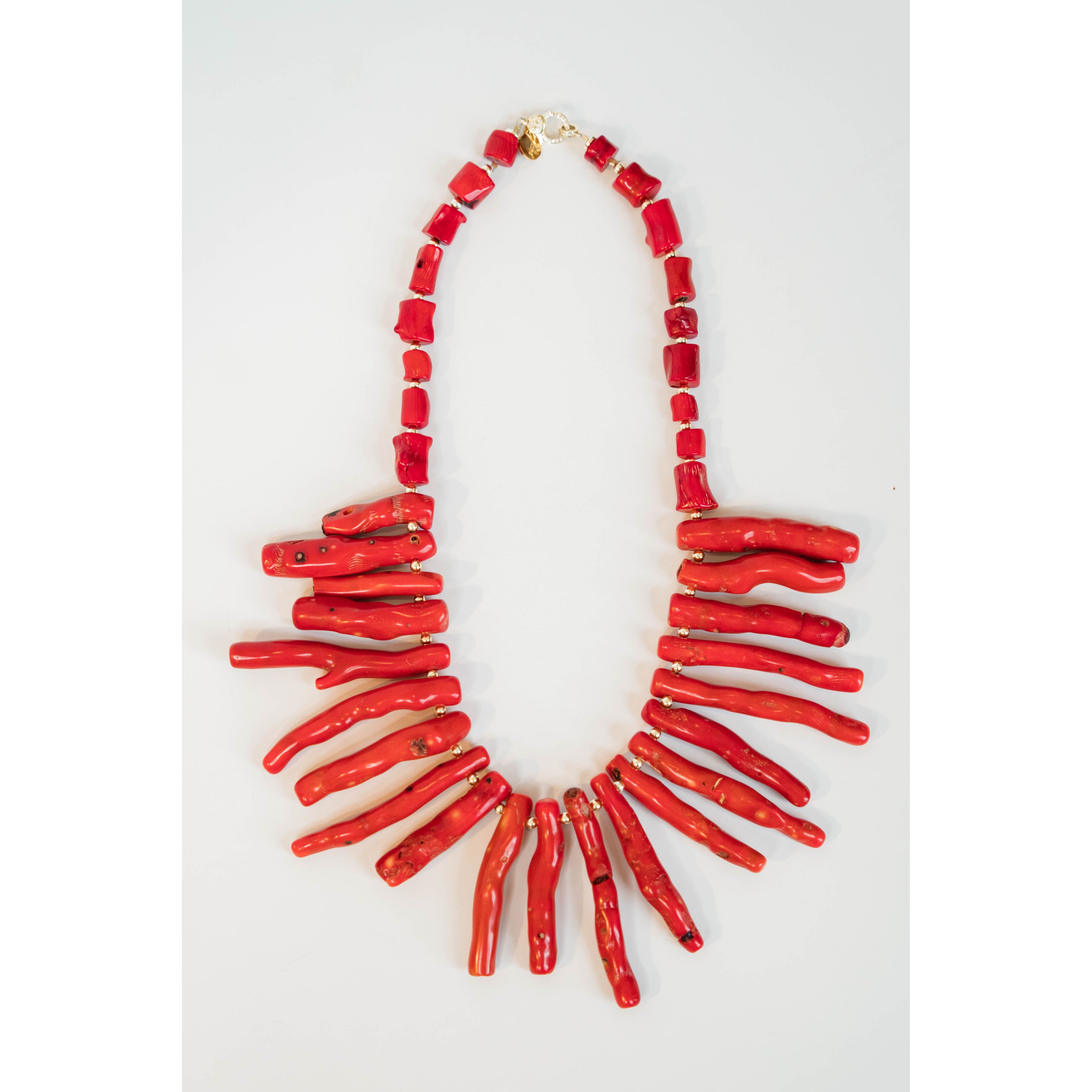red coral collared necklace with coral-like charms draping the neck against a light background