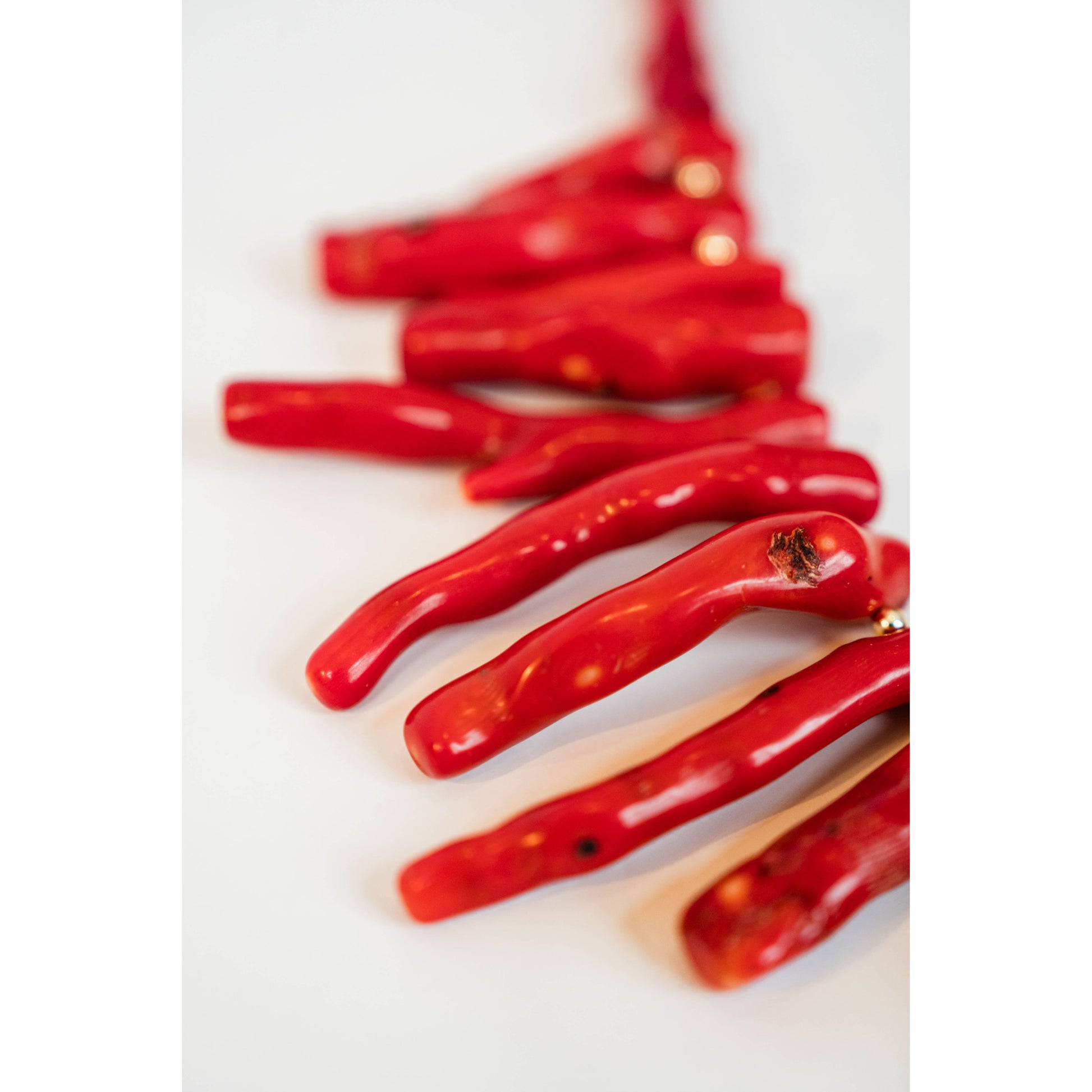 red coral beaded necklace on a light grey background