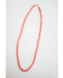 coral pink shell beaded necklace on a light gray background