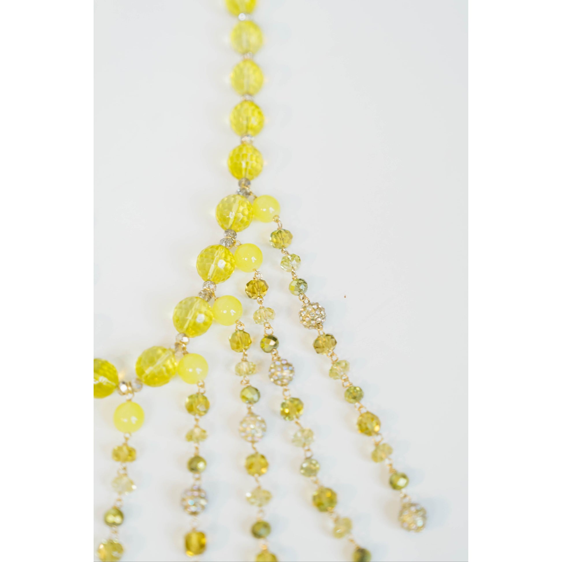 beaded necklace with yellow toned crystal bead accents on a light grey background