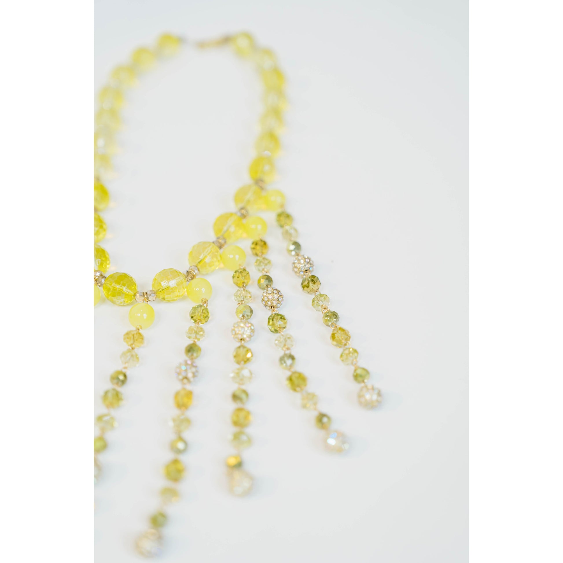 beaded necklace with yellow toned crystal bead accents on a light grey background