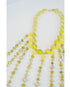 beaded necklace with yellow toned crystal bead accents on a light grey background