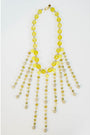 beaded necklace with yellow toned crystal bead accents on a light grey background