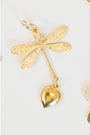 Gold dragonfly pendant with a heart charm on a white background