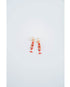 Pair of red and gold fish-shaped earrings on a light gray background