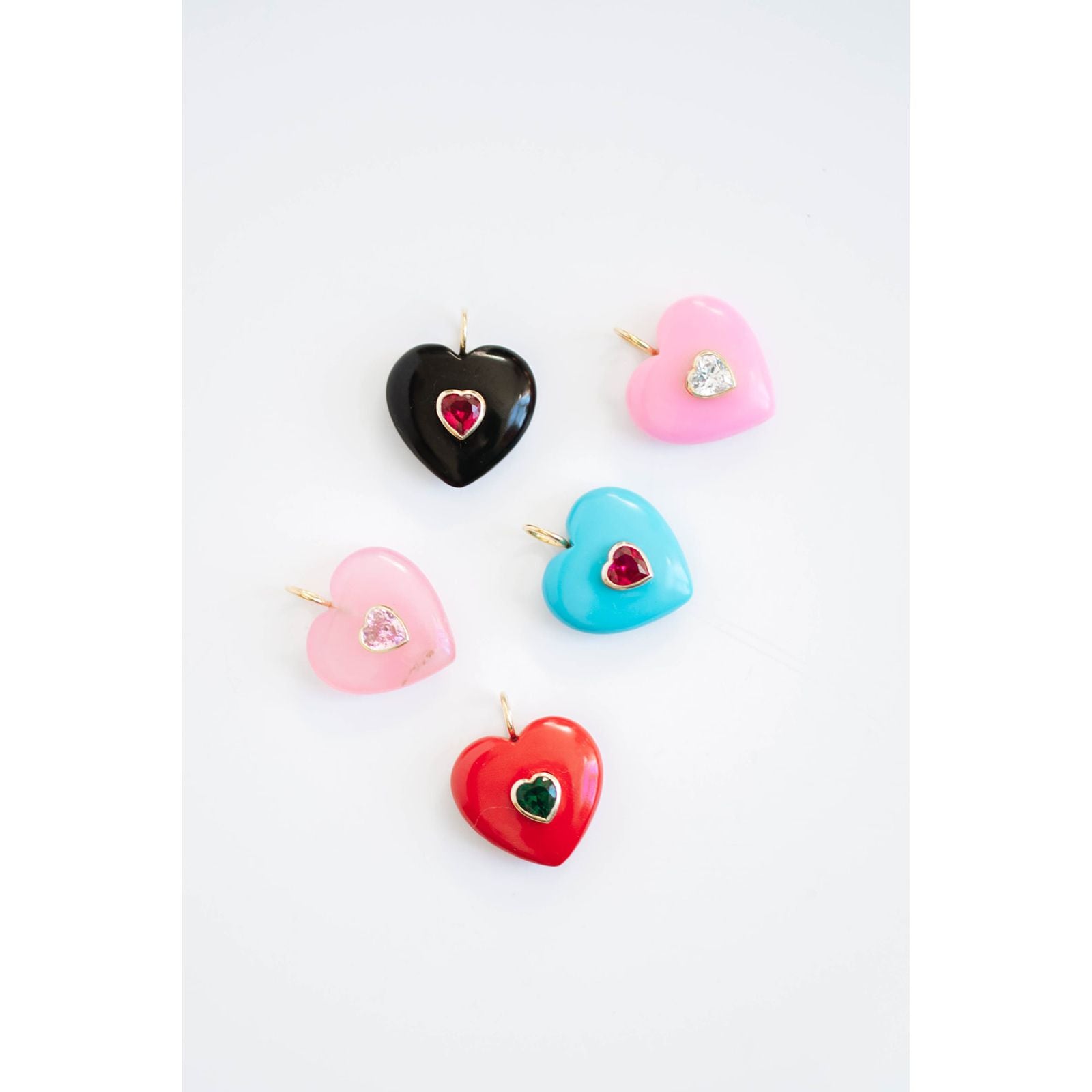 Colorful heart-shaped pendants with crystal accents on a white background