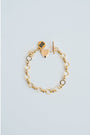 Gold chain bracelet with heart-shaped charm and toggle clasp on a light blue background