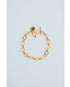 Gold chain bracelet with heart-shaped charm and toggle clasp on a light blue background