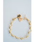 Gold bracelet with heart charm and toggle clasp on a light blue background