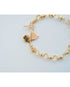Gold chain bracelet with heart charm and toggle clasp on a light gray background