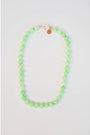 round light green beaded necklace with a gold pave lever clasp against a light background