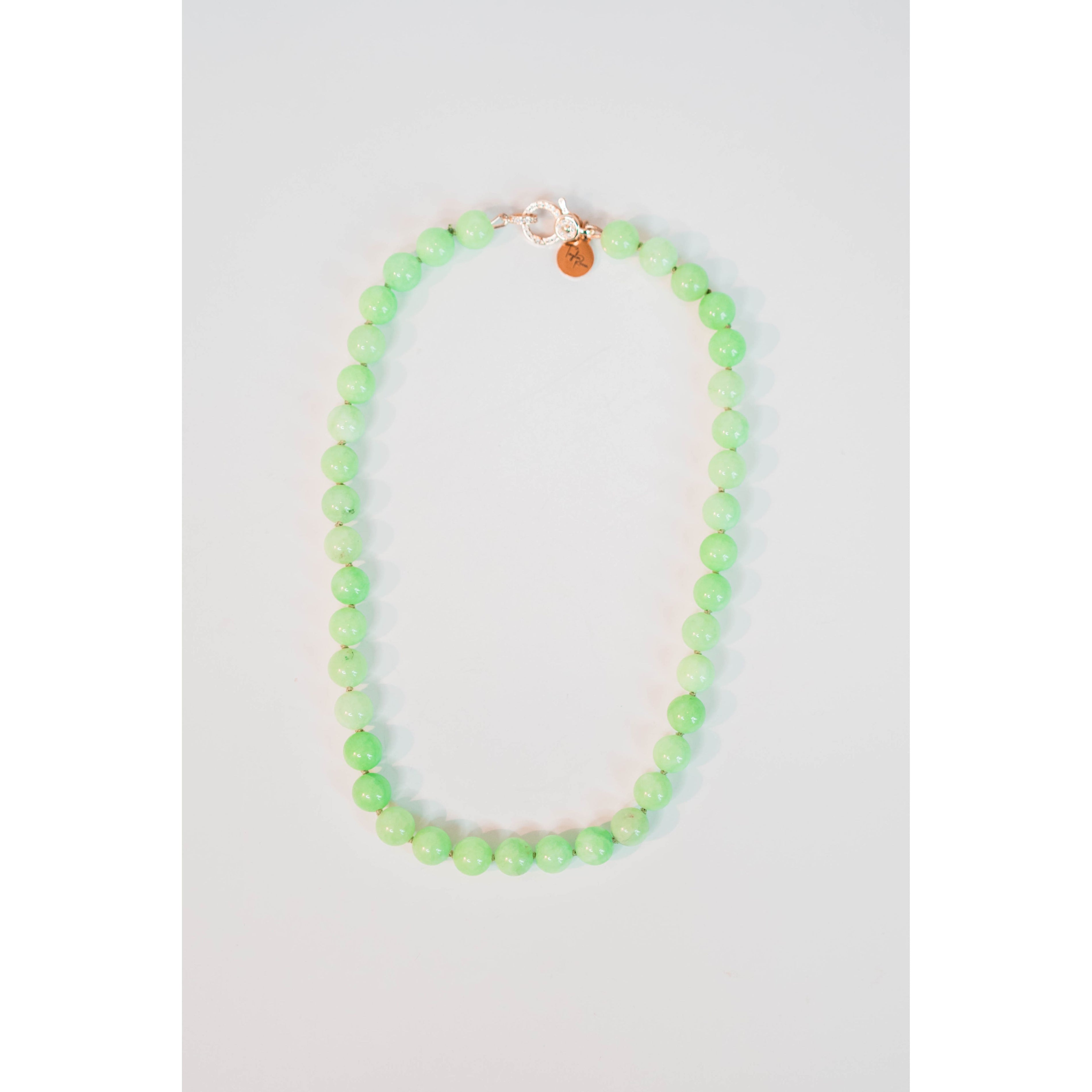 round light green beaded necklace with a gold pave lever clasp against a light background