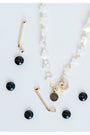 necklace with white star beads placed by gold hockey stick charms with pave detailing