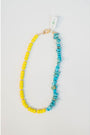 split necklace with neon yellow beads and turquoise howlite beads on a light background