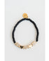 Black beaded bracelet with gold pave heart-shaped charms on a light grey background