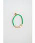 Green beaded bracelet with gold pave heart accents on a light gray background